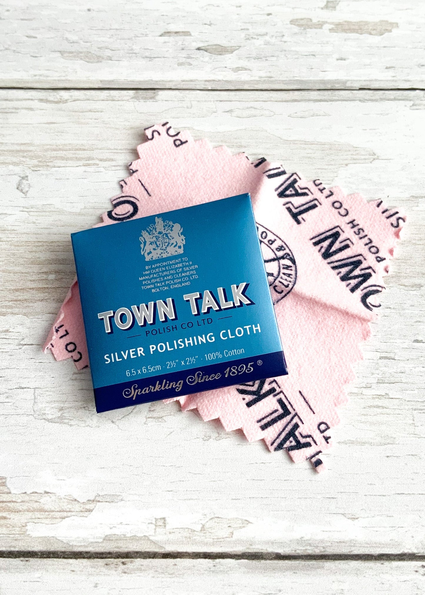 A high quality pink polishing cloth for jewellery photographed alongside its packaging, one included with every order