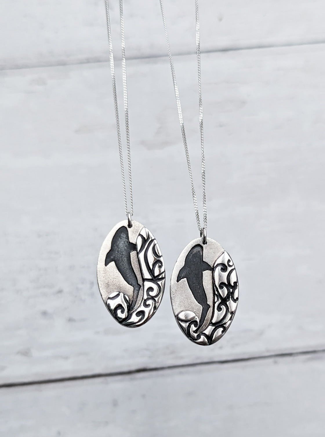 Silver shark silhouette necklace with tribal wave