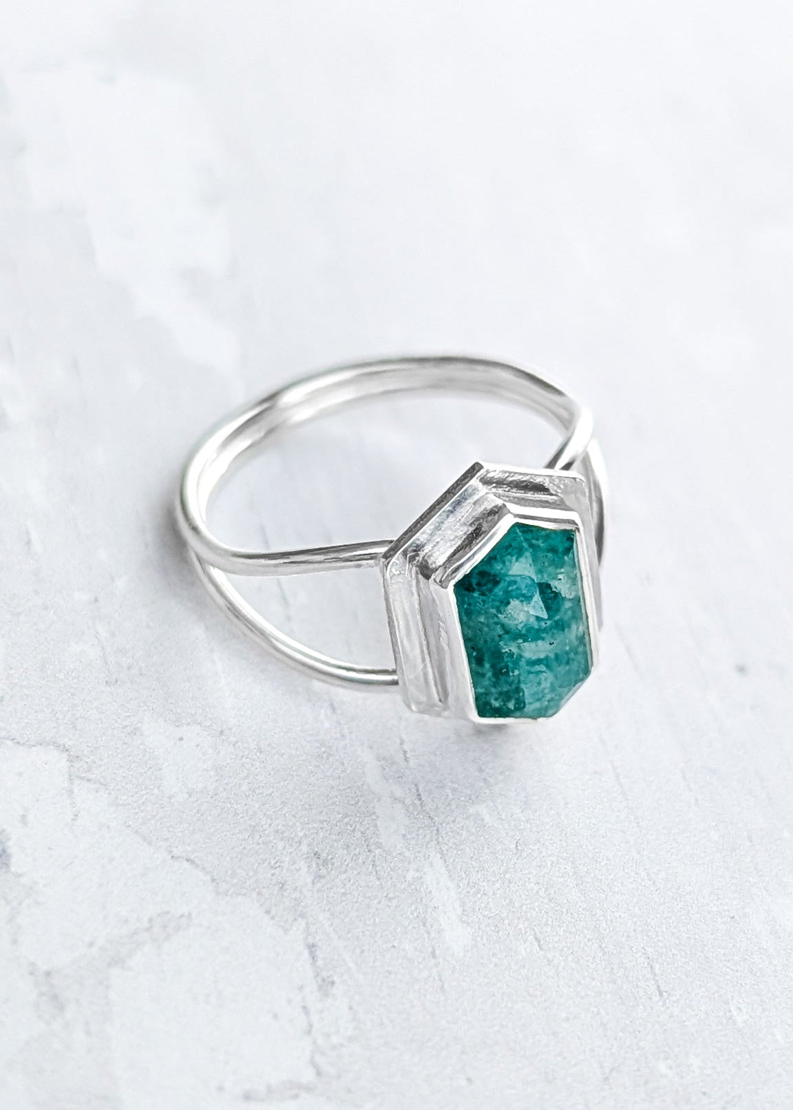 Closeup of a looped double banded silver ring with turquoise hezagon Amazonite gemstone on the front