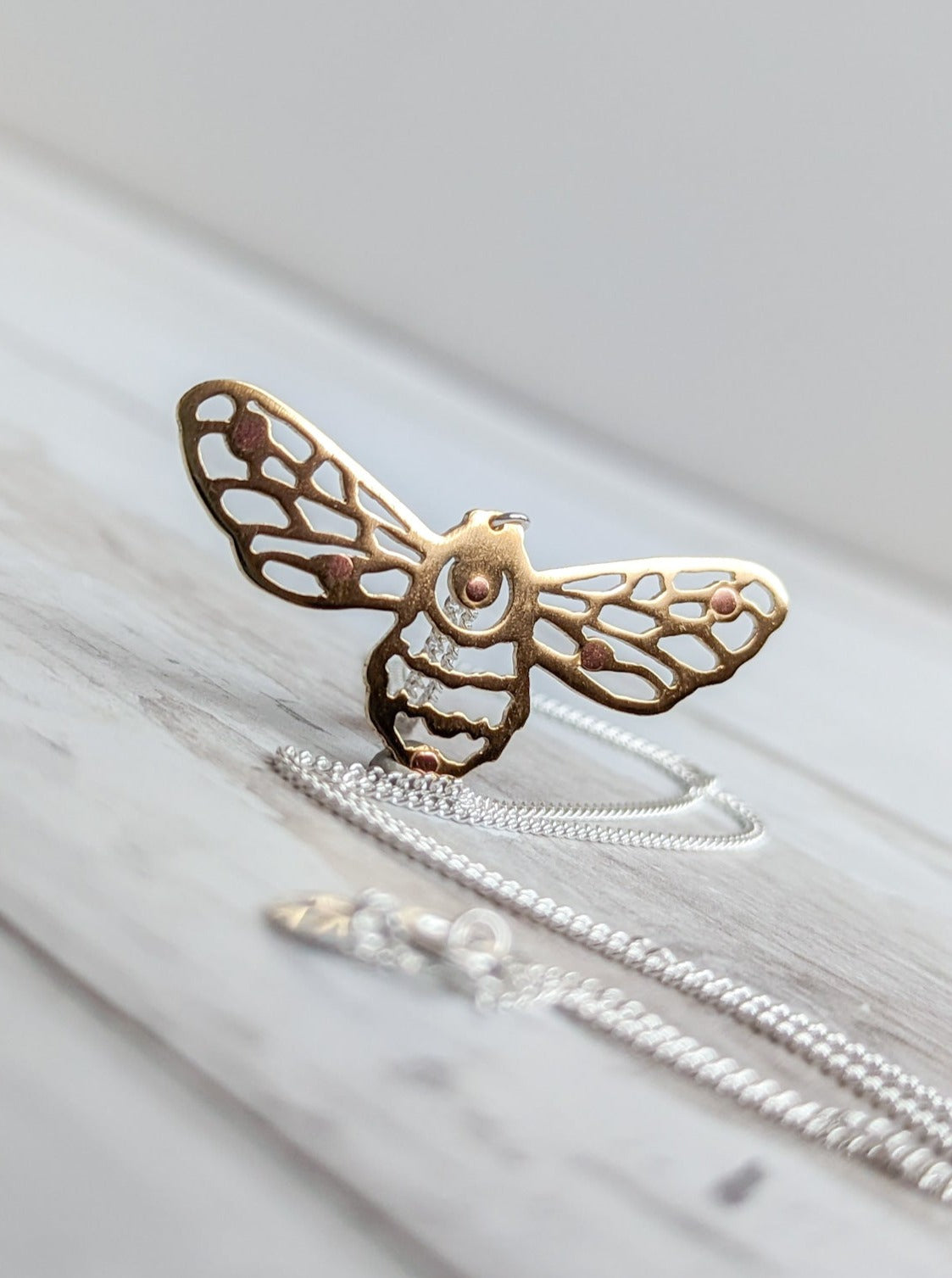 Cut-out brass bee pendant