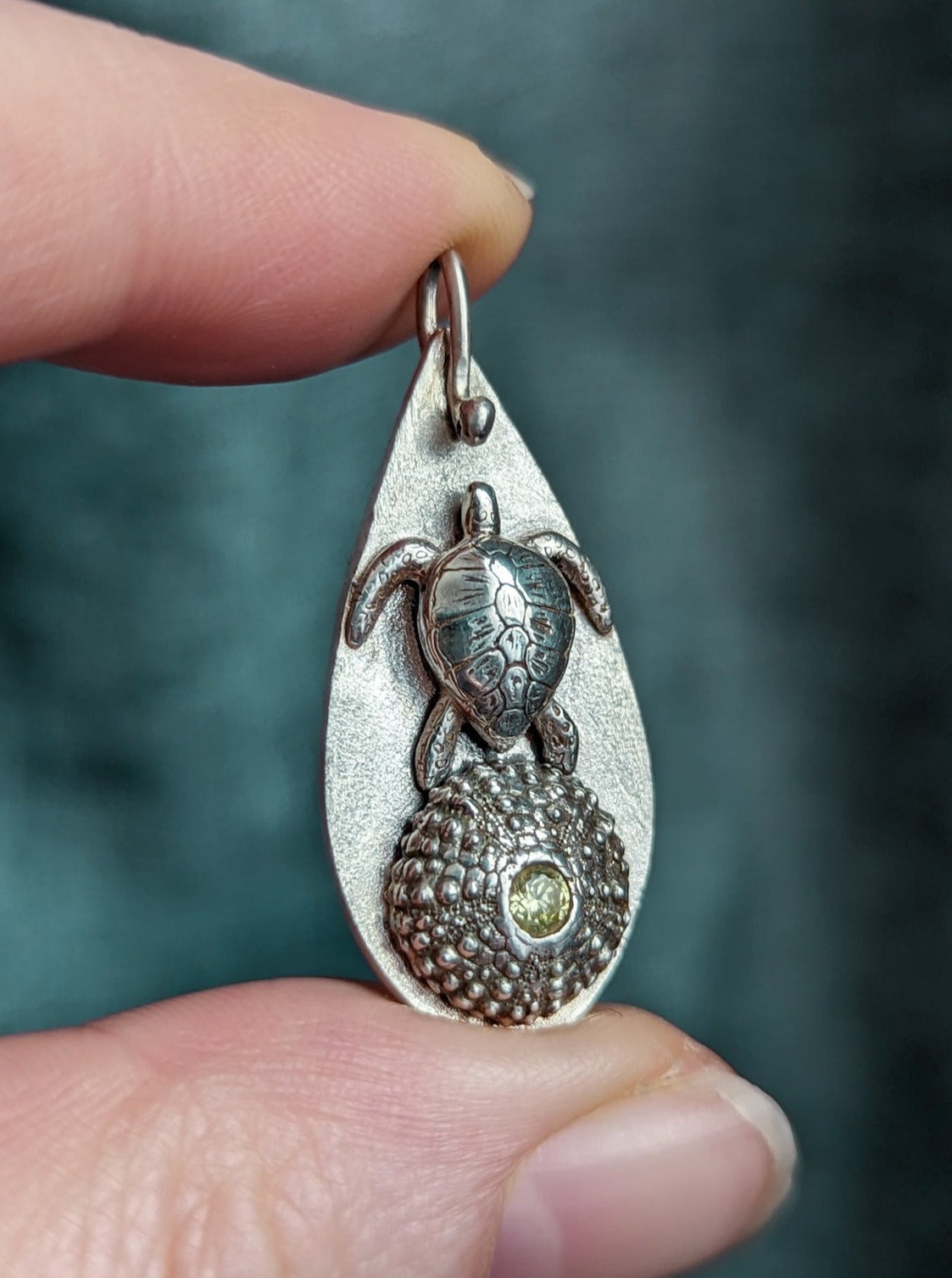 Silver totem talisman featuring a sea turtle and sea urchin shell