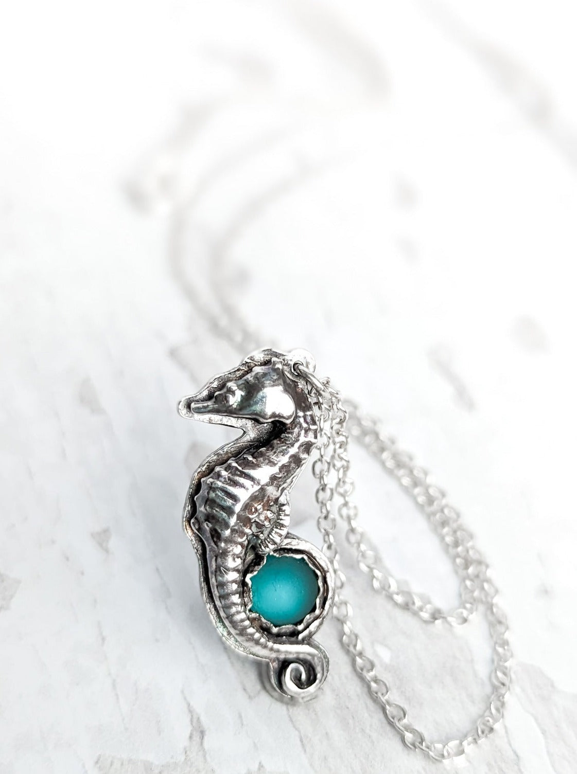 Silver seahorse necklace with round blue sea glass