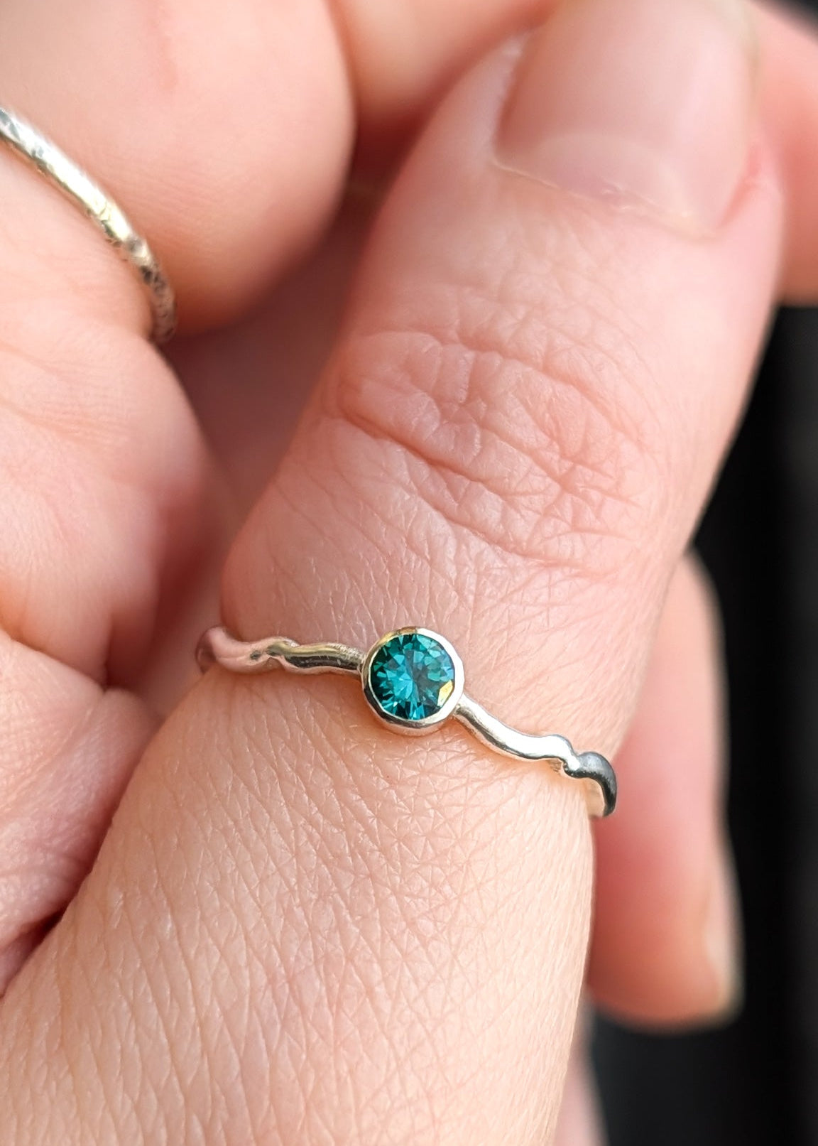 Closeup of a hand wearing a turquoise solitaire ring on the thumb